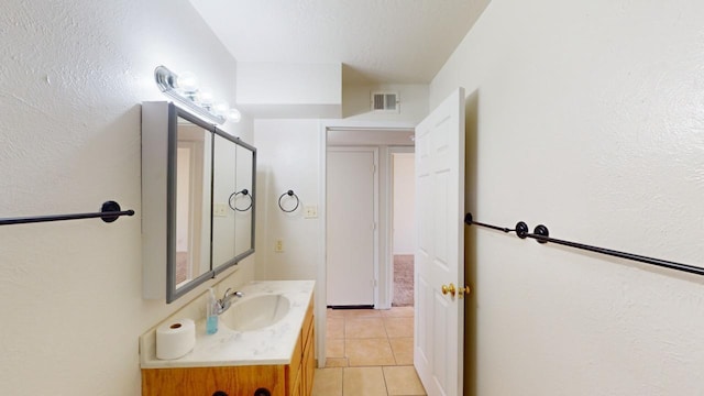 bathroom with tile patterned flooring, vanity, and a textured ceiling