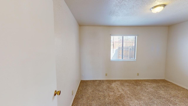 empty room with light carpet and a textured ceiling