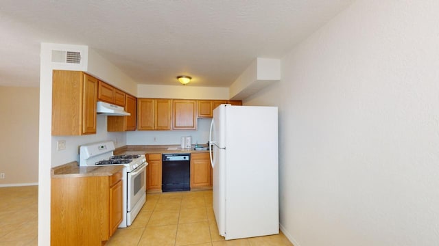 kitchen with a textured ceiling, light tile patterned floors, and white appliances