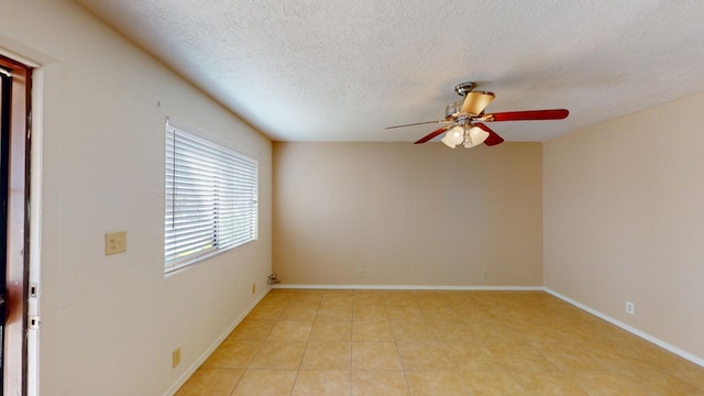 unfurnished room featuring ceiling fan, light tile patterned flooring, and a textured ceiling