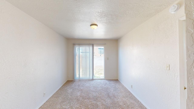 carpeted spare room with a textured ceiling