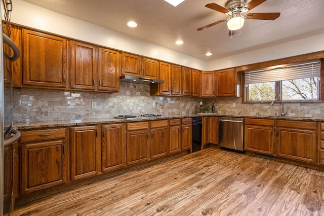 kitchen with tasteful backsplash, light hardwood / wood-style flooring, stainless steel appliances, and sink