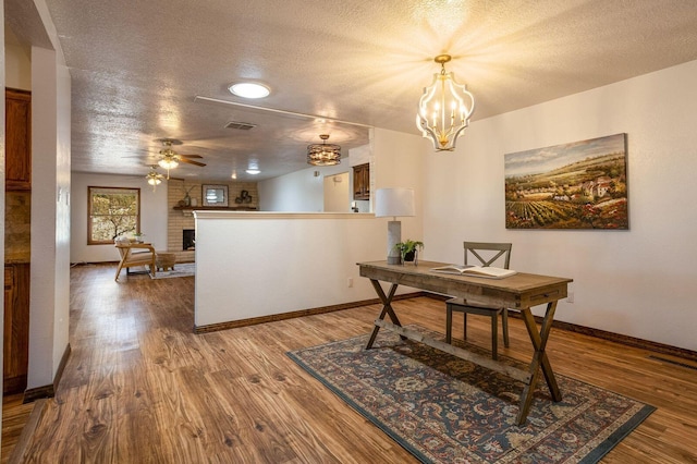 office area featuring ceiling fan with notable chandelier, a textured ceiling, and hardwood / wood-style floors