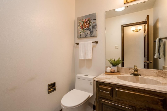 bathroom featuring vanity with extensive cabinet space and toilet