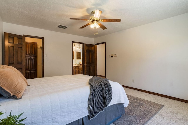 carpeted bedroom with connected bathroom, ceiling fan, and a textured ceiling