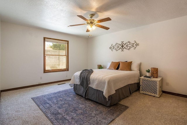 carpeted bedroom with ceiling fan and a textured ceiling