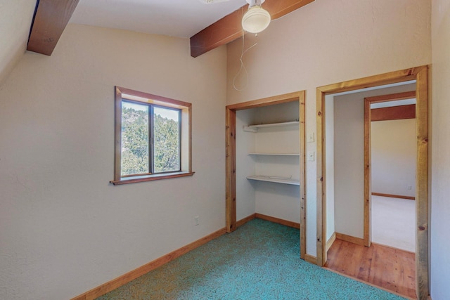 unfurnished bedroom with beam ceiling, a closet, carpet floors, and ceiling fan