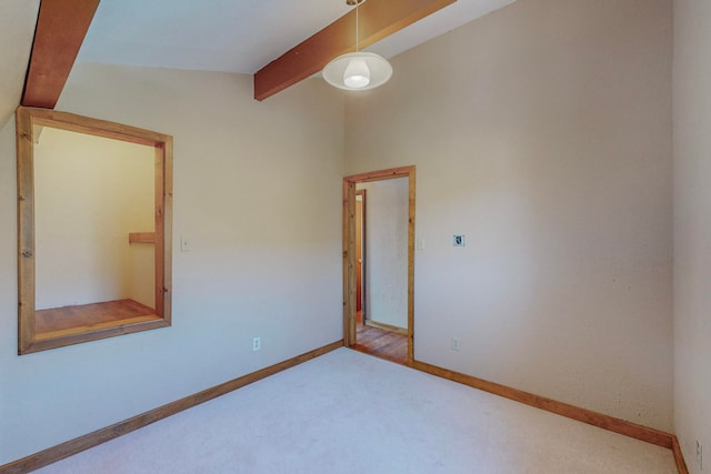 carpeted empty room featuring lofted ceiling with beams