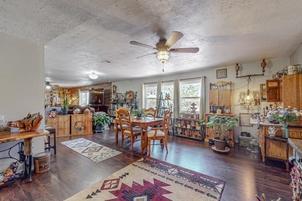 dining room with ceiling fan, dark hardwood / wood-style floors, and a textured ceiling