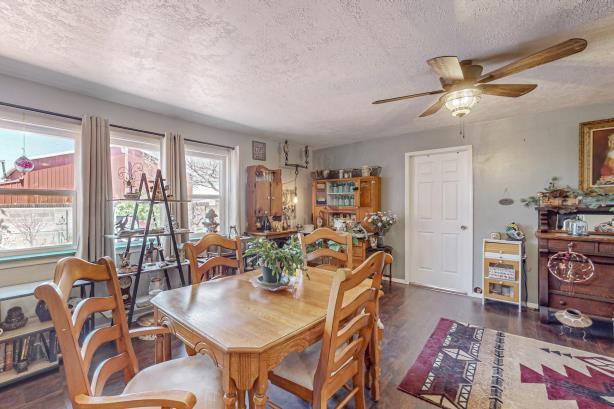 dining area featuring dark hardwood / wood-style flooring, ceiling fan, and a textured ceiling