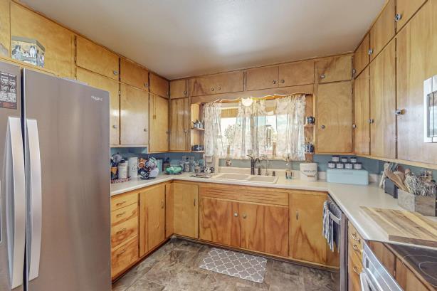 kitchen featuring sink, appliances with stainless steel finishes, and light tile floors