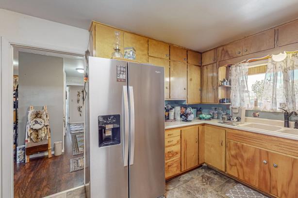 kitchen with sink, light tile floors, and stainless steel fridge with ice dispenser