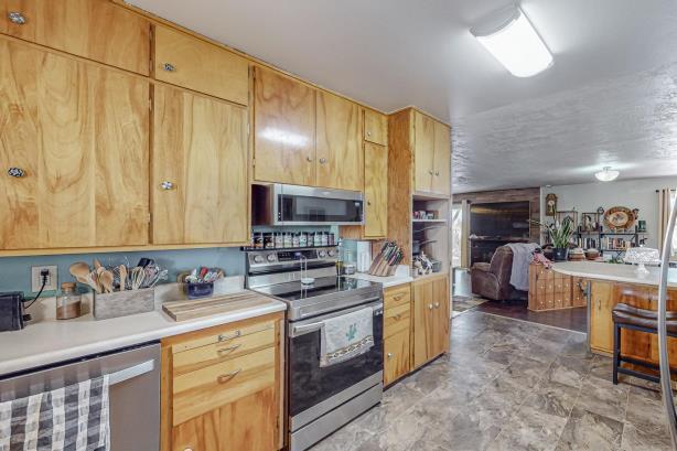 kitchen with light brown cabinetry, appliances with stainless steel finishes, and light tile floors