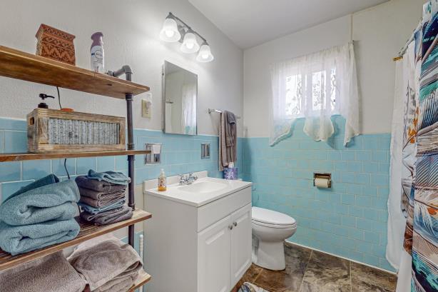 bathroom with tile walls, large vanity, backsplash, tile floors, and toilet