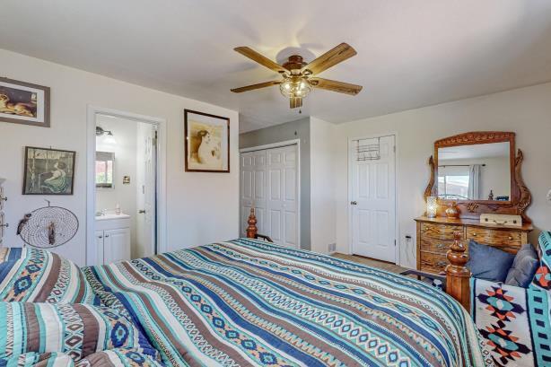 bedroom with a closet, connected bathroom, and ceiling fan