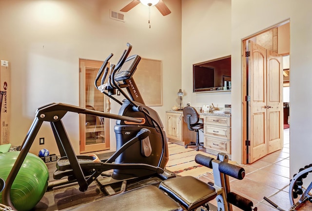 workout area featuring ceiling fan and a high ceiling