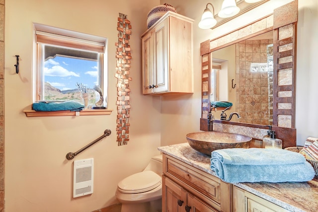 bathroom featuring vanity, toilet, and heating unit