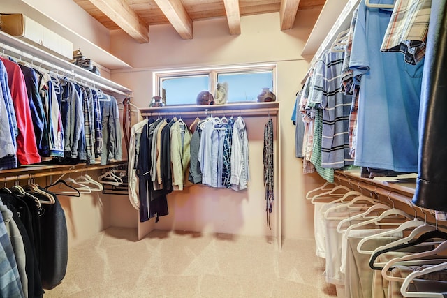 walk in closet featuring beamed ceiling and carpet floors