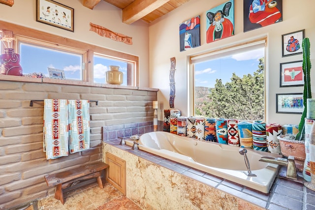 bathroom with beamed ceiling, wood ceiling, and tiled tub