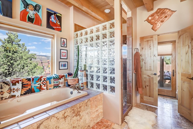 bathroom with a wealth of natural light, plus walk in shower, and beamed ceiling