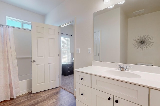 bathroom with plenty of natural light, large vanity, shower / tub combo, and hardwood / wood-style flooring