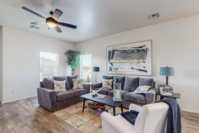 living room featuring wood-type flooring and ceiling fan