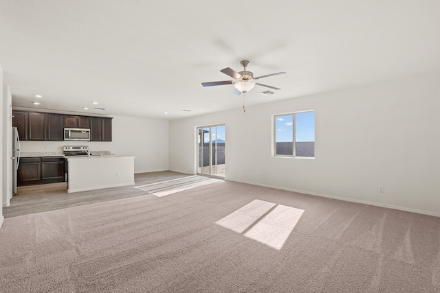 unfurnished living room featuring light colored carpet and ceiling fan