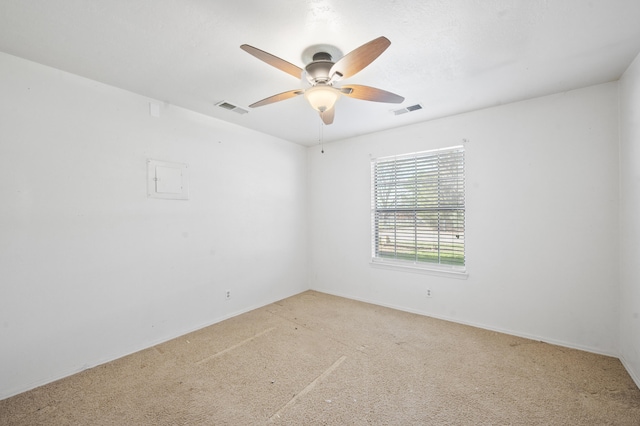 unfurnished room with light carpet, visible vents, and a ceiling fan