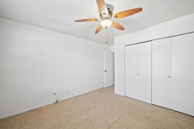 unfurnished bedroom featuring a closet, a ceiling fan, and carpet flooring