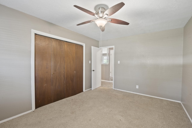 unfurnished bedroom featuring ceiling fan, carpet floors, a closet, and baseboards