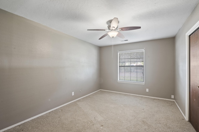 unfurnished room featuring baseboards, carpet, visible vents, and a textured ceiling