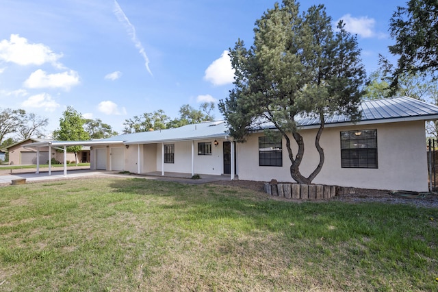 ranch-style house featuring metal roof, an attached carport, driveway, stucco siding, and a front yard