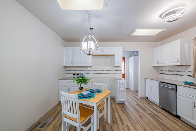 kitchen with dishwasher, light stone countertops, and white cabinets