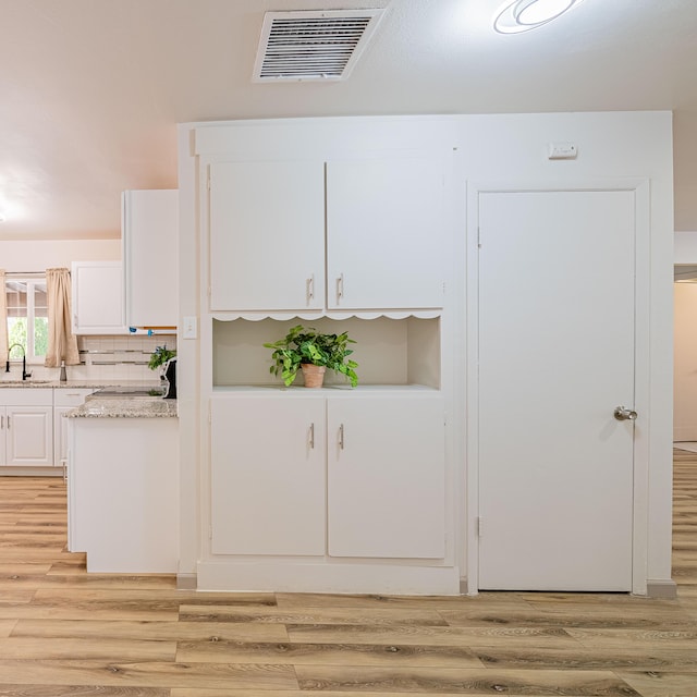 details with hardwood / wood-style flooring, sink, and backsplash