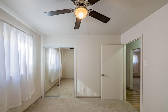 unfurnished bedroom featuring light colored carpet, a closet, and ceiling fan