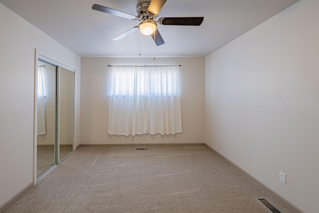 unfurnished bedroom featuring light carpet, a closet, and ceiling fan