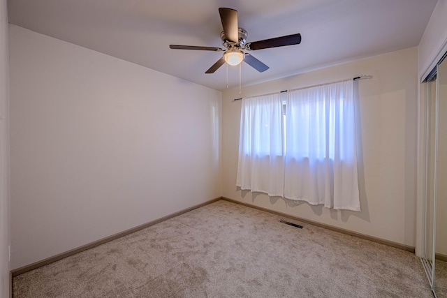 unfurnished room with light colored carpet and ceiling fan