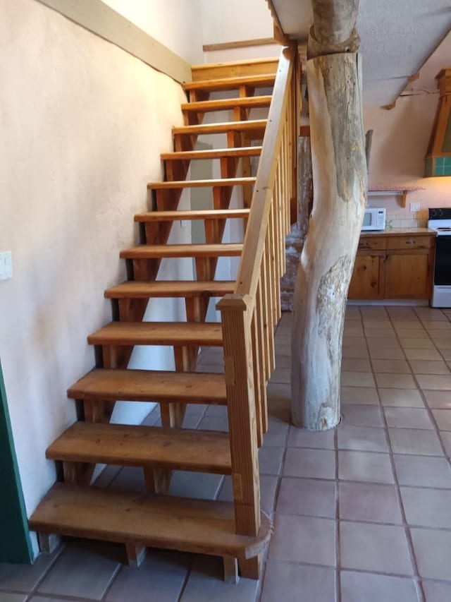 staircase with tile floors and a textured ceiling