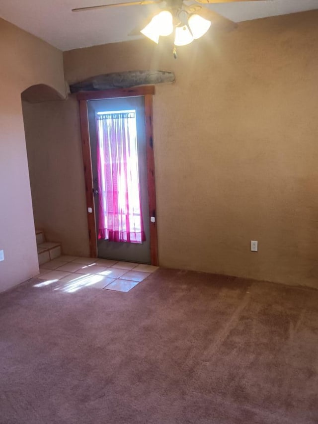 carpeted spare room with ceiling fan