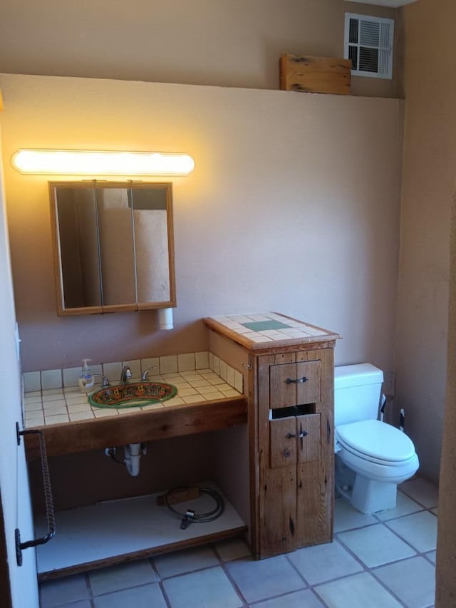 bathroom with tile floors, sink, and toilet