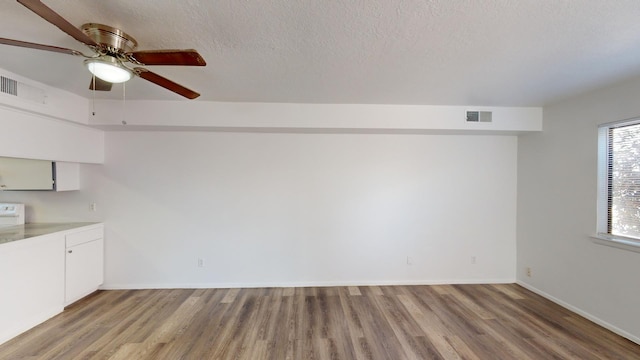 interior space with ceiling fan, a textured ceiling, and light hardwood / wood-style floors