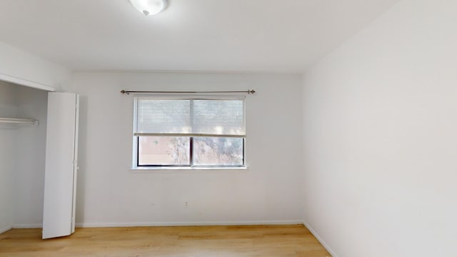 unfurnished bedroom with light wood-type flooring and a closet