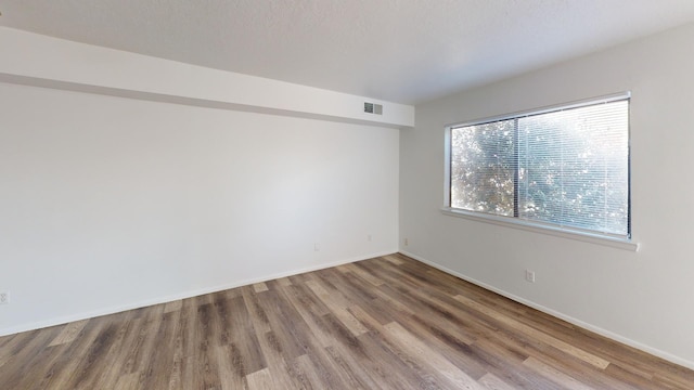 spare room with hardwood / wood-style floors