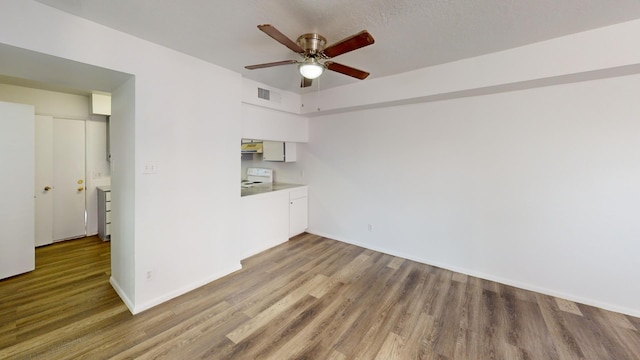 unfurnished living room featuring ceiling fan and hardwood / wood-style floors