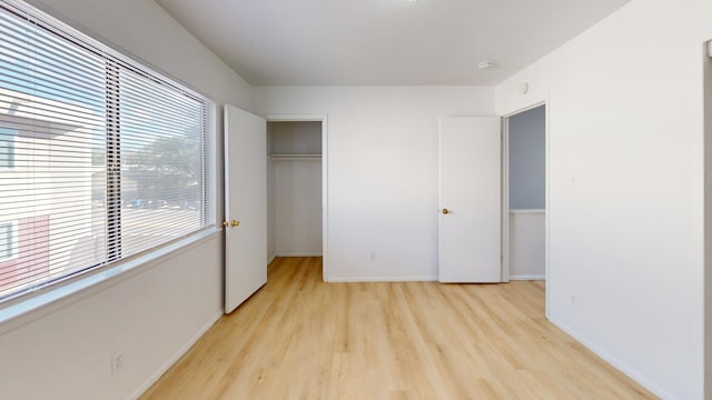 unfurnished bedroom featuring light hardwood / wood-style flooring and a closet