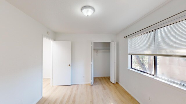 unfurnished bedroom with a closet and light hardwood / wood-style floors