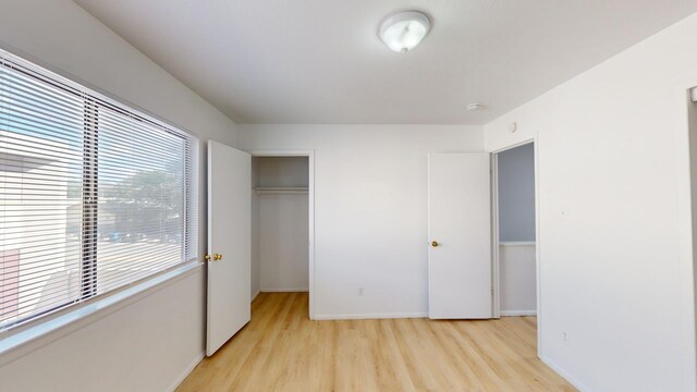 unfurnished bedroom featuring light hardwood / wood-style flooring and a closet