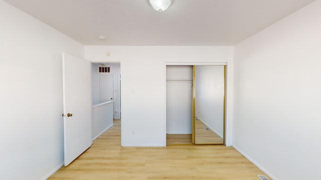 unfurnished bedroom featuring a closet and light hardwood / wood-style floors