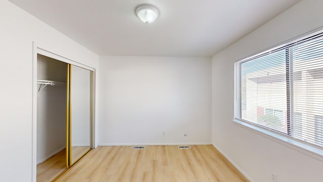 unfurnished bedroom with light hardwood / wood-style floors and a closet