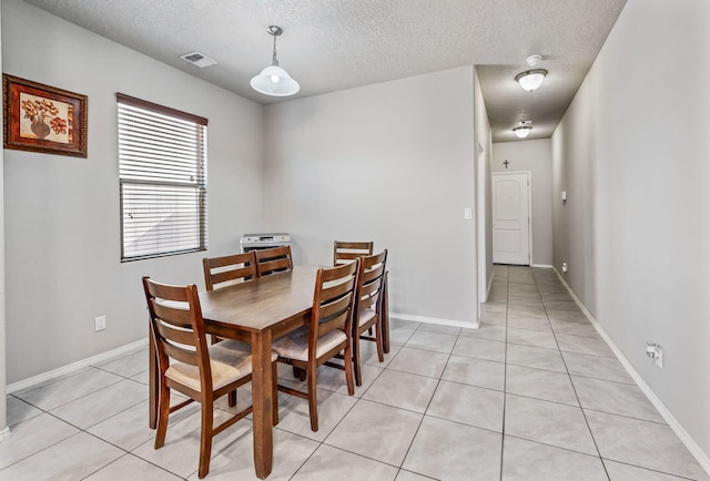 tiled dining space with a textured ceiling